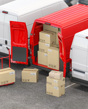 Red delivery van with open doors and hand truck with cardboard b