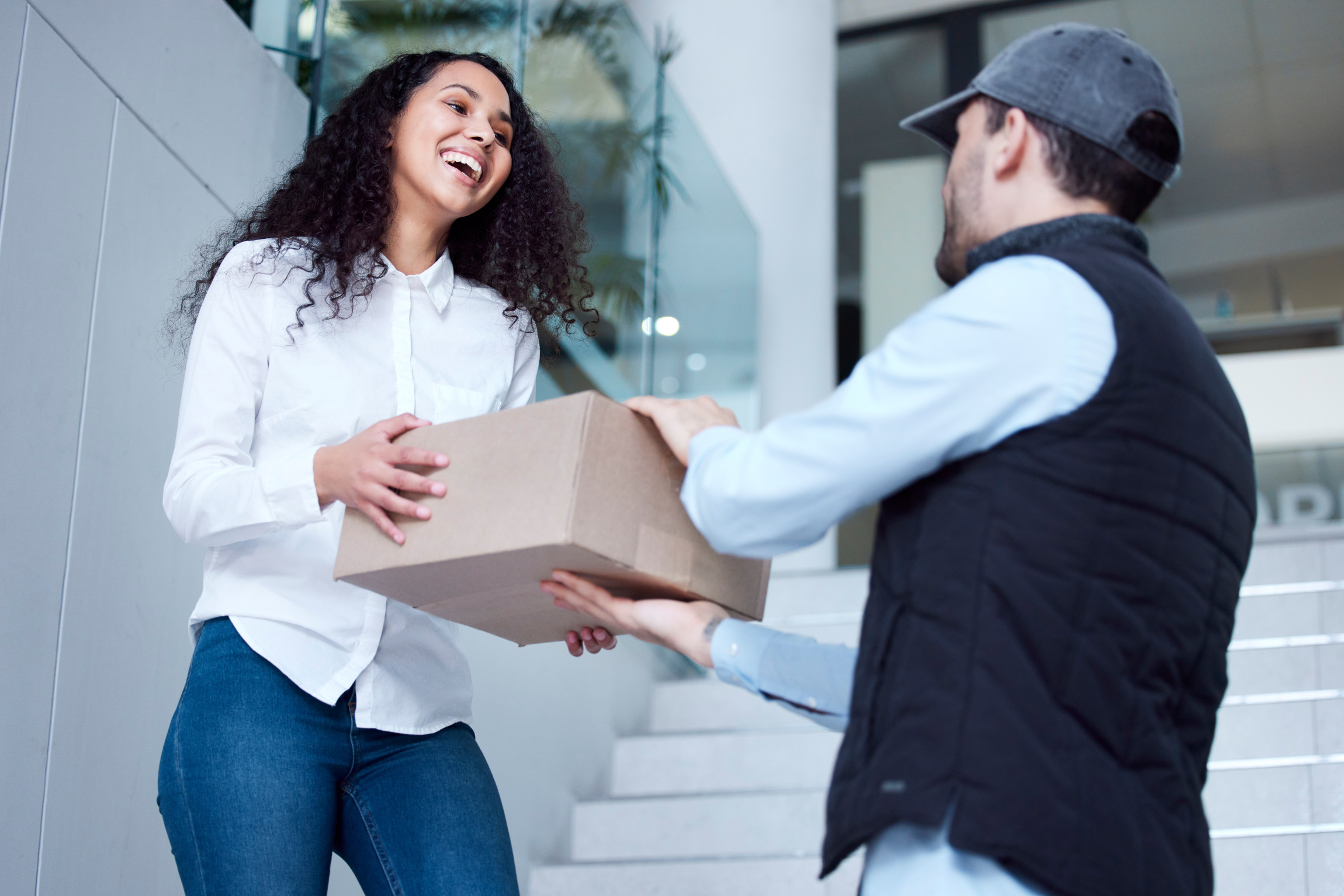 Shot of a young woman receiving her delivery from the courier.