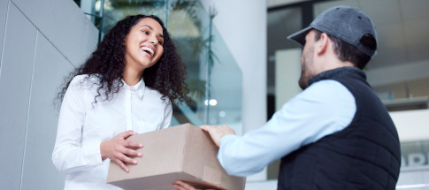 Shot of a young woman receiving her delivery from the courier.